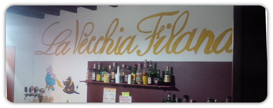 L'insegna dipinta a mano La Vecchia Filanda dietro al banco.